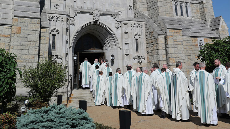 Outdoor photo of priests entering church